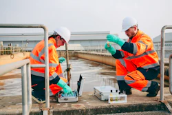 Two workers conducting water quality testing. | Photo by iStock