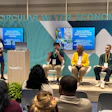 Panel discussion on circular water economy at conference with four speakers and audience members seated in front of branded backdrop.