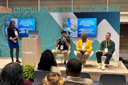 Panel discussion on circular water economy at conference with four speakers and audience members seated in front of branded backdrop.